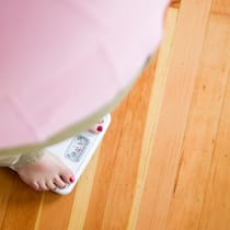 Wenn Sie Ihre Pfunde satt haben Eine übergewichtige Frau steht auf der Waage.