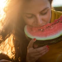 Coole Rezepte für heisse Tage Frau beisst in Wassermelone