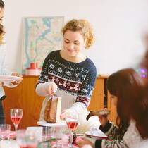 Leichter schlemmen Zwei Frauen verteilen an Weihnachten Kuchenstücke an die Familie.