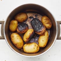 Ganz und gar ungeniessbar Eine Pfanne mit verbrannten Kartoffeln.