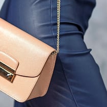 Im Web gekauft – was kann ich tun? Eine Frau trägt eine kleine beige Handtasche mit sich.