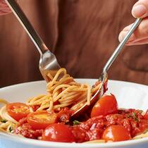 Abnehmen ohne Verbote Eine Frau dreht Spaghetti auf einem Löffel auf.