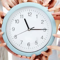 Frist verpasst – was jetzt? In der Mitte liegt eine Uhr, die viertel nach elf anzeigt. Zudem zeigen rund um die Ihr herum viele Hände mit dem Finger auf die Uhr. Beim Ausfüllen der Steuererklärung gelten bestimmte Fristen. Was passiert, wenn man diese nicht einhält?