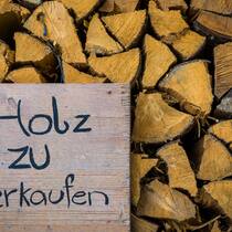 Der Trick mit dem Holz, das es nicht gibt Stapel Brennholz, Schild, Holz zu verkaufen