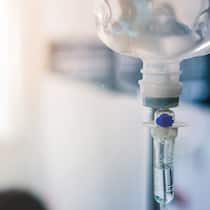 Wie teuer darf die Chance auf Gesundheit sein? Close up eines IV-Tropfs im Raum eines Patienten