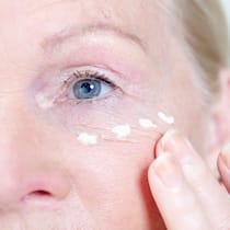 Teure Crèmes mit schwacher Wirkung Frau trägt Crème auf ihre Wange auf