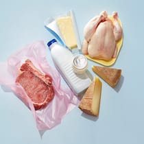 Essen mit gutem Gewissen Rindfleisch sowie diverse Milchprodukte liegen auf einer blauen Oberfläche.