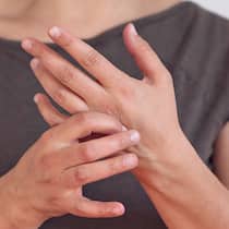 Gut gedrückt ist halb geheilt Eine Frau massiert sich mit der rechten Hand die linke.