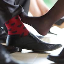 Warum können wir nicht anders? Eine Frau in Stöckelschuhen berührt unter dem Tisch mit dem rechten Fuss das Scheinbein eines Mannes im Anzug