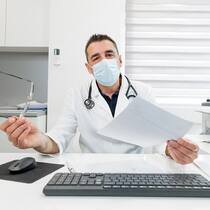 Arzt verweigert Behandlung, weil Patient nicht unterschreibt Arzt mit Dokument in der Hand