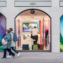 Kündigung nur noch per Chat und Telefon Fensterfront des UPC-Stores am Limmatquai in Zürich, an dem zwei Spaziergängerinnen vorbeigehen.