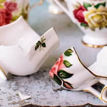 Hilfe für zerstrittene Erben Kaffeetassen mit einem floralen Muster liegen zerbrochen auf einem Tisch.