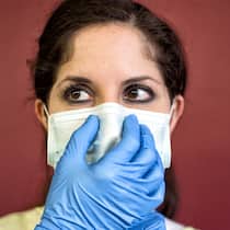 «Eine sehr ernst zu nehmende Gefahr» Eine Pflegerin mit Spitalhandschuhen rückt die Gesichtsmaske zurecht.