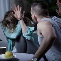 Kann ich die Anzeige zurückziehen? Ein Mann holt zum Schlag auf eine Frau aus. Die gewalttätige Szene spielt sich zu Hause ab.