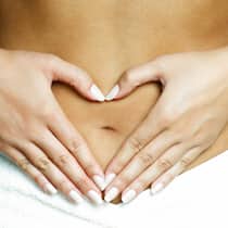 Darm-Kur – In 3 Monaten zu einem «guten Bauchgefühl» Frau formt mit ihren Händen ein Herz auf ihrem Bauch