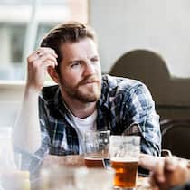 Andere Ansichten – und trotzdem Freunde Ein Mann schaut seinen Freund ungläubig an.