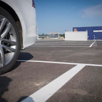 Der übelste Parkplatz der Schweiz Bild des privaten Parkplatzes an der Shoppingmeile in Lyssach. Ein Auto steht auf einem der Parkfelder.