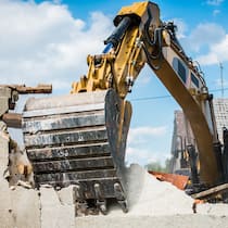 Wenn der Lärm zu viel wird Bagger zerstört eine Hausmauer