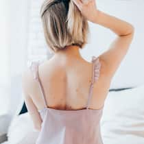 Der Krebs-Scanner sieht alles Eine Frau mit rückenfreiem Pyjama und Muttermalen