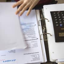 Was Sie über die Prämienverbilligung wissen müssen Eine junge Frau bei der Berechnung ihrer Krankenversicherungskosten.