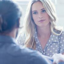 He Chef, bitte keine faulen Ausreden! Eine junge Mitarbeiterin sieht ihren Chef mit resigniertem Blick an während sie in einem Mitarbeitergespräch über den Lohn sprechen.