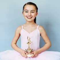 «Es ist ein Ringen um Normalität» Kind in Ballettkleid hält einen Pokal in den Händen