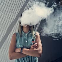 Nikotin soll angeblich Leben retten Young woman with her head in a cloud of vapor smoke