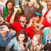 Jedes Foto ist geschützt Eine Gruppe junger Menschen steht in einer Masse zusammen und alle halten ein Handy oder eine Digitalkamera in die Höhe.