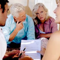 Schenken ja – aber richtig Ein älteres Paar bespricht sich mit ihren beiden erwachsenen Kindern zu Dokumenten. Dabei geht es um eine erbrechtliche Schenkung respektive um einen Erbvorbezug.