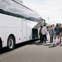 Aufschlag bei Pauschalreise gerechtfertigt? Eine Gruppe Touristen wartet vor einem Car aufs Einsteigen.
