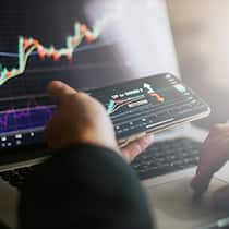 Mit ein paar Klicks Vermögen verloren Mann handelt am Laptop mit Bitcoins