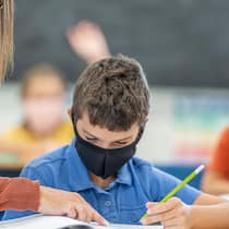 Bundesgericht stützt Maskenpflicht an Schulen Eine Lehrerin erklärt einem Schüler eine Aufgabe, beide tragen eine Maske.