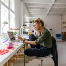 «Man muss wieder zusammenfinden» Eine Angestellte eines Ateliers sitzt im verlassenen Büro vor ihrem Laptop.