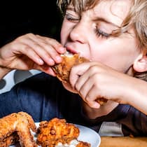 Warum uns «Soul Food» so guttut Ein Junge isst Poulet - Manches Essen weckt Erinnerungen und sorgt für gute Laune. Es lohnt sich also, darauf zu achten, was auf den Teller kommt