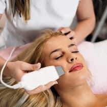 18’000 Franken für zweifelhaftes Diplom? Kosmetikerin verurteilt Beautiful young blonde woman receiving professional face ultrasonic peeling treatment. Cosmetology specialist doing modern procedure of cleaning face with ultrasonic scrubber.