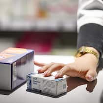 Zusatzgebühren der Apotheken gehen ins Geld – und auf die Nerven Apothekerin zeigt auf Medikamente - Obligatorische Beratungsgebühren in den Apotheken ärgern besonders die chronisch kranken Kunden: Sie wissen längst, wie sie die Medikamente anwenden müssen. Wer online bestellt, kann sparen