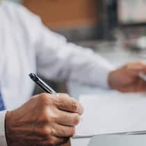 28’000 Franken Vorschuss – und plötzlich fordert der Anwalt fast nochmals so viel Lawyer signing document in the office