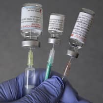 So diktierte Moderna der Schweiz die Impfstoff-Lieferung BONN, GERMANY - APRIL 27: In this illustration photo, taken in a Bonn vaccination center, shows a doctor's hand with medical syringes and the original vaccination vials from Moderna, Comirnaty (Pfizer/BioNTech) and Nuvaxovid (Novavax) on April 27, 20…