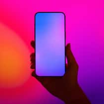 Ein neues Handy für mehr Lebensqualität Close-up shot of a female hand holding smartphone with blank screen against illuminated LED digital display screen. Mockup image. Connecting to the future. Futuristic. Artificial intelligence. Innovation and technology concept2203621915