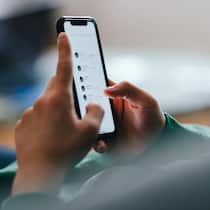 KI-Nacktbilder im Klassenchat – das müssen Eltern wissen Unrecognizable teenage boy typing text messages on his smartphone while lying on a couch at home.
1481613618