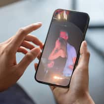 Fremdgeh-Fotos vom Coldplay-Konzert – das sagt das Gesetz dazu Close-up of a businessman hand holding a smartphone white screen is blank the background is blurred.Mockup.
