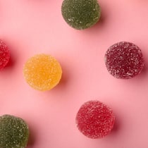 Vermeintliches Wundermittel für schöne Haut entzaubert Assorted candies marmalade with different colors on pink background. Top view
