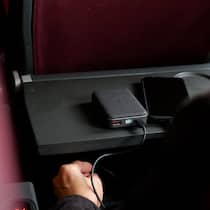 Diese Regeln gelten für Powerbanks im Flugzeug Ein Fluggast lädt in einem Flugzeug sein Smartphone mithilfe einer Powerbank auf.
