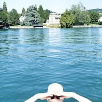 Wie gut kennen Sie die Superreichen der Schweiz? Eine junge Frau mit Badekappe und Sonnenbrille haelt von einem Schiff aus Ausschau, aufgenommen im Sommer 2006 vor der "Goldkueste" im Kanton Zuerich. (Stefan Jaeggi by KEYSTONE)
SCHWEIZ SOMMER