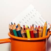 Dank Spenden die Schulden reduziert – und einen Neubeginn ermöglicht Invoice in an orange jar of colored pencils on white background with copy space