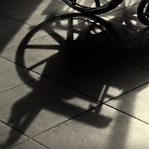 Stiftung zahlt Stehhilfe für einen Paraplegiker Shadow of a wheelchair, showing part of the wheelchair at the top of the image.
