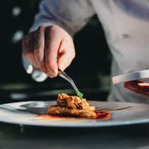 Fernsehkoch kassierte Monate lang doppelt – Gericht zwingt ihn zur Rückzahlung A chef is finishing the preparation of the plate. He's decorating the plate just before the serving.