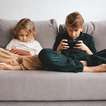 Darum macht der Bildschirm Kinder zu Hektikern und Träumerinnen Beautiful little girl and teenager boy with smartphone. Leisure, children, technology and people concept