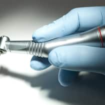 Studierende drohen mit Strafanzeigen gegen Professoren Montage: Zentrum für Zahnmedizin der Universität Zürich und Zahnarzthand mit Bohrer.