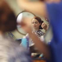 Das sind Ihre Rechte, wenn der Coiffeur pfuscht Reflection of a woman having her hair styled.